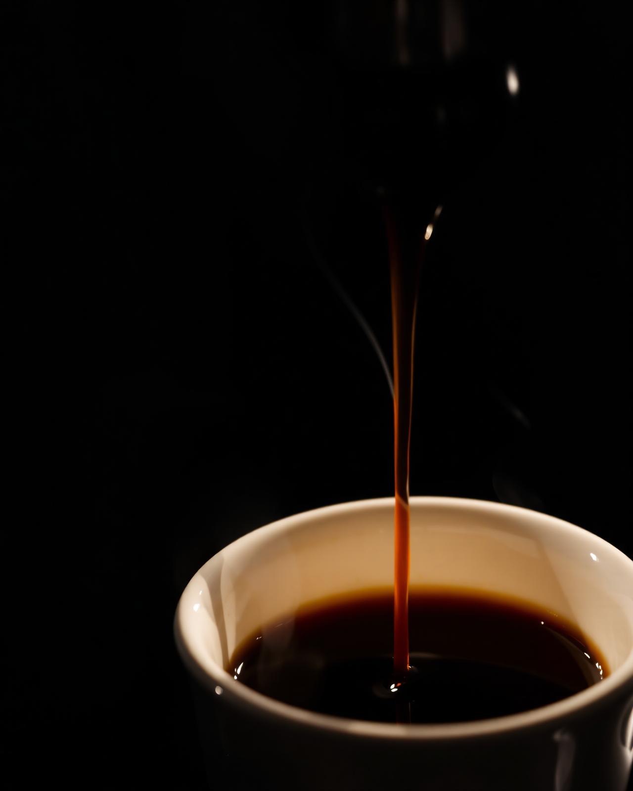 Espresso pouring into a ceramic cup